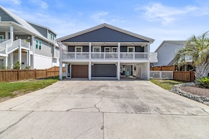 A two-story house with a front porch, a garage, and a fenced yard.