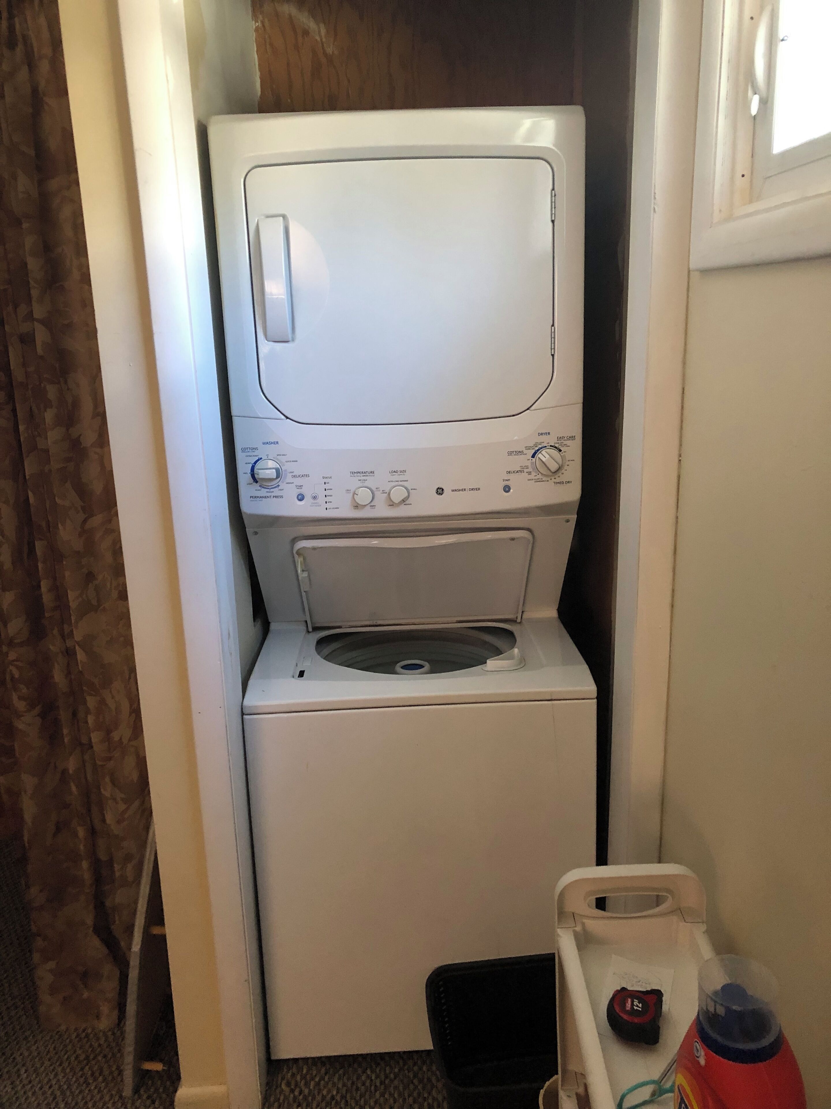 Een compacte, witte wasmachine met een voorlaadklep, een bedieningspaneel met verschillende instellingen en een klein, afgesloten zeepbakje.