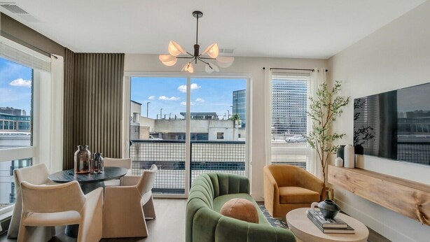 Un salon moderne comprenant un canapé, des fauteuils, une table à manger et un téléviseur.