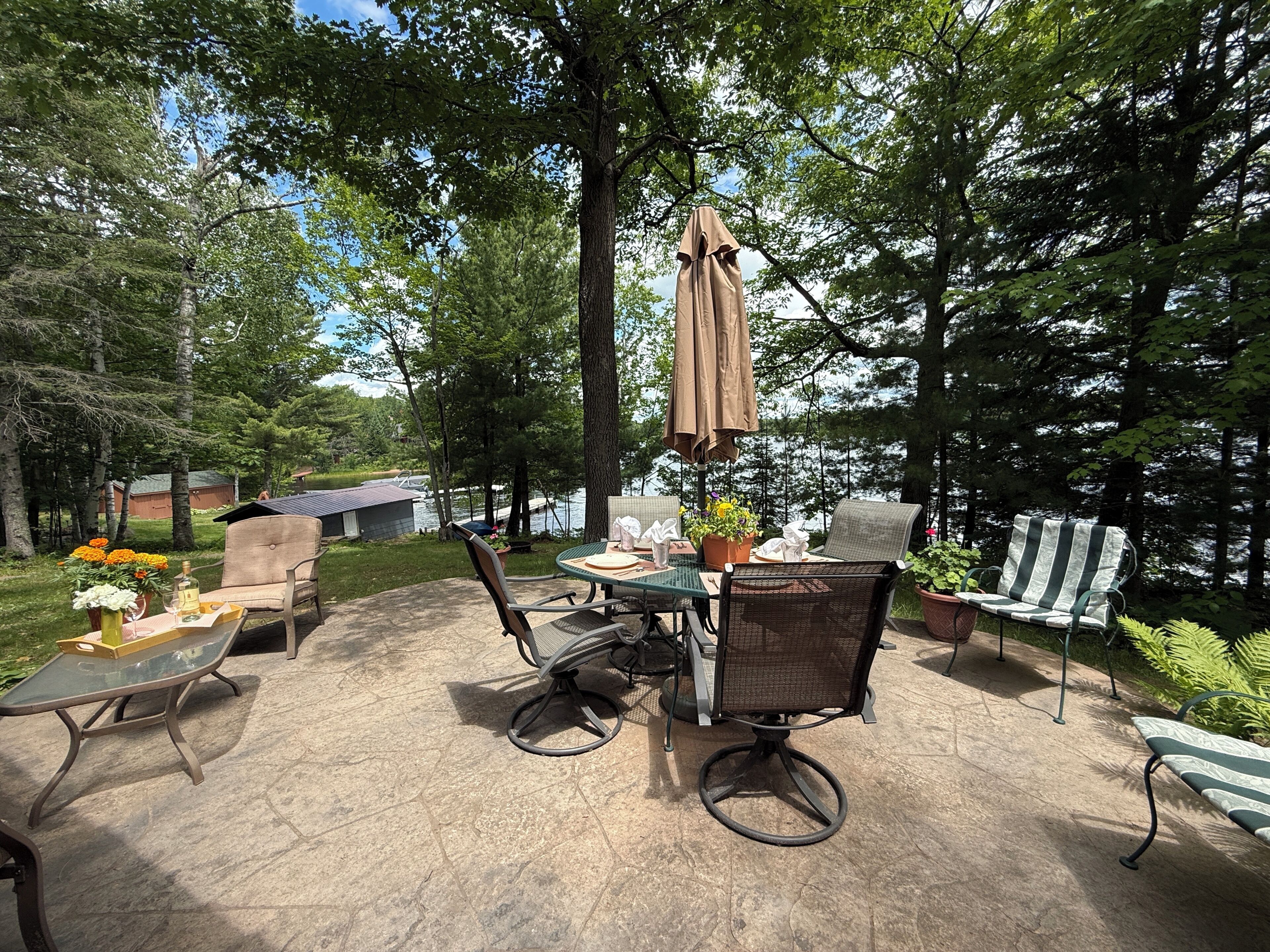 Une terrasse extérieure avec une table, des chaises et un parasol.