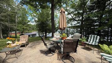 Une terrasse extérieure avec une table, des chaises et un parasol.