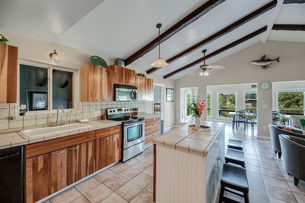 A spacious kitchen with wooden cabinets, a stainless steel stove, and a large island.