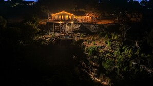 A two-story building with a staircase leading to a deck, surrounded by natural vegetation. - BoGi - 3/2 Canyon Lake Waterfront + Sweeping Lake Views Off Multiple Decks + Ping Pong + Games (Canyon Lake)