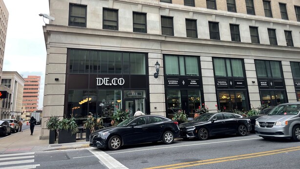 A multi-story building with a prominent 'DE.CO' sign on the ground floor.
