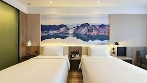 A hotel room with two beds, a large mountain view painting, and a wooden floor. - Atour Hotel（Beijing Chaoyang Park Red Scarf Bridge） (Beijing)