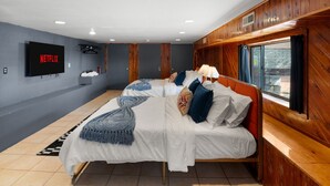 Ein modernes Schlafzimmer mit zwei Betten, einem Fernseher und einem Fenster mit Blick.