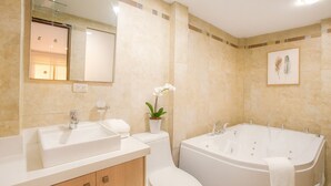 A modern bathroom with a bathtub, a toilet, and a sink. - Esmeralda Shelter - Jacuzzi (Cuenca)