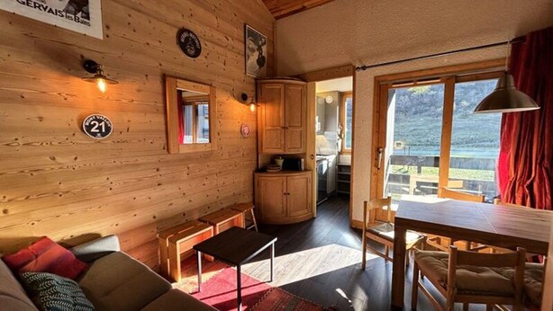 A cozy cabin interior with a wooden interior, a dining area, and a view of the outdoors. - Bear Hollow D151 (Les Allues)