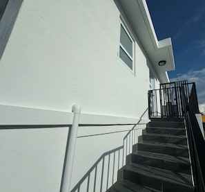 Ein weißes Gebäude mit einer schwarzen Treppe und einem Geländer.