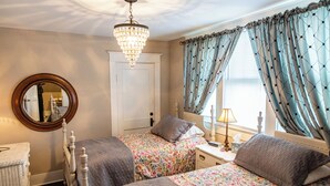 A bedroom with two single beds, a chandelier, a mirror, and a window with curtains. - Guest House of Kentucky (2 Singles - 2nd Floor) (Lancaster)