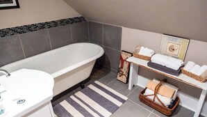 A bathroom with a bathtub, a sink, a mirror, and a towel rack. - Guest House of Kentucky (2 Singles - 2nd Floor) (Lancaster)