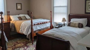 A bedroom with two beds, a chandelier, and a patterned rug. - Gate House (2 Doubles + 1 Single - 2nd Floor) (Lancaster)