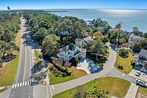 An aerial view of a residential area with houses, a road, and a body of water.