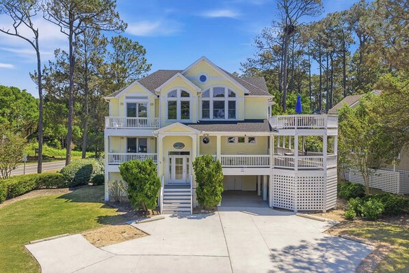 A two-story house with a front porch, a covered deck, and a driveway.