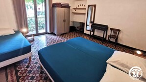 Ein Zimmer mit zwei Betten, einem Schreibtisch, einem Stuhl, einem Kleiderschrank und einem fenster mit Vorhängen.