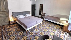 Ein Zimmer mit einem Bett, einem Sessel und einem kleinen Tisch.