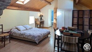 A cozy attic bedroom with a bed, a desk, and a dining table. - Ferme les Taillades 2-4 persons (CAMBON ET SALVERGUES)