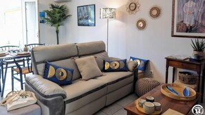 A living room with a sofa, coffee table, and decorative items. - L'Arcolan - VALRAS PLAGE (VALRAS PLAGE)
