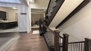 A modern interior with a wooden staircase, a kitchen area, and a living room. - Clean and Spacious 4-bdrm Family home in Whitby! (Whitby)