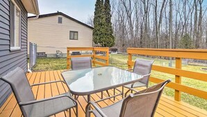 A deck with a glass-top table and four chairs, surrounded by a wooden railing. - Charming Columbus Home about 7 Mi to Ohio State! (Columbus)