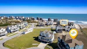 A coastal residential area with houses, a clear view of the beach, and a sign indicating beach access. - Whelk – Dog-Friendly & Steps from Buxton Beach (Buxton)