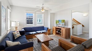 A living room with a blue sofa, wooden coffee table, and patterned rug. - Barracuda: Cozy Buxton Getaway w/ Ocean Views (Buxton)