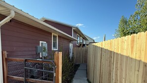 Une rangée de maisons de plain-pied, séparées par une clôture en bois.