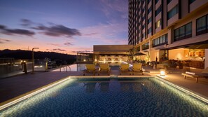A rooftop pool with lounge chairs and a bar area. - Ormond Sandakan (Sandakan)