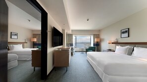 A hotel room with two beds, a desk, a TV, and a large window with a city view. - Ormond Sandakan (Sandakan)