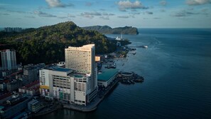 A coastal cityscape with a prominent hotel named 'ORION' featuring a modern design, waterfront access, and a view of the sea. - Ormond Sandakan (Sandakan)