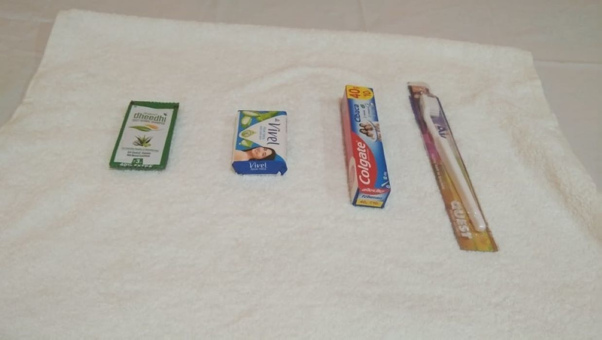Four boxes of oral care products on a white towel.