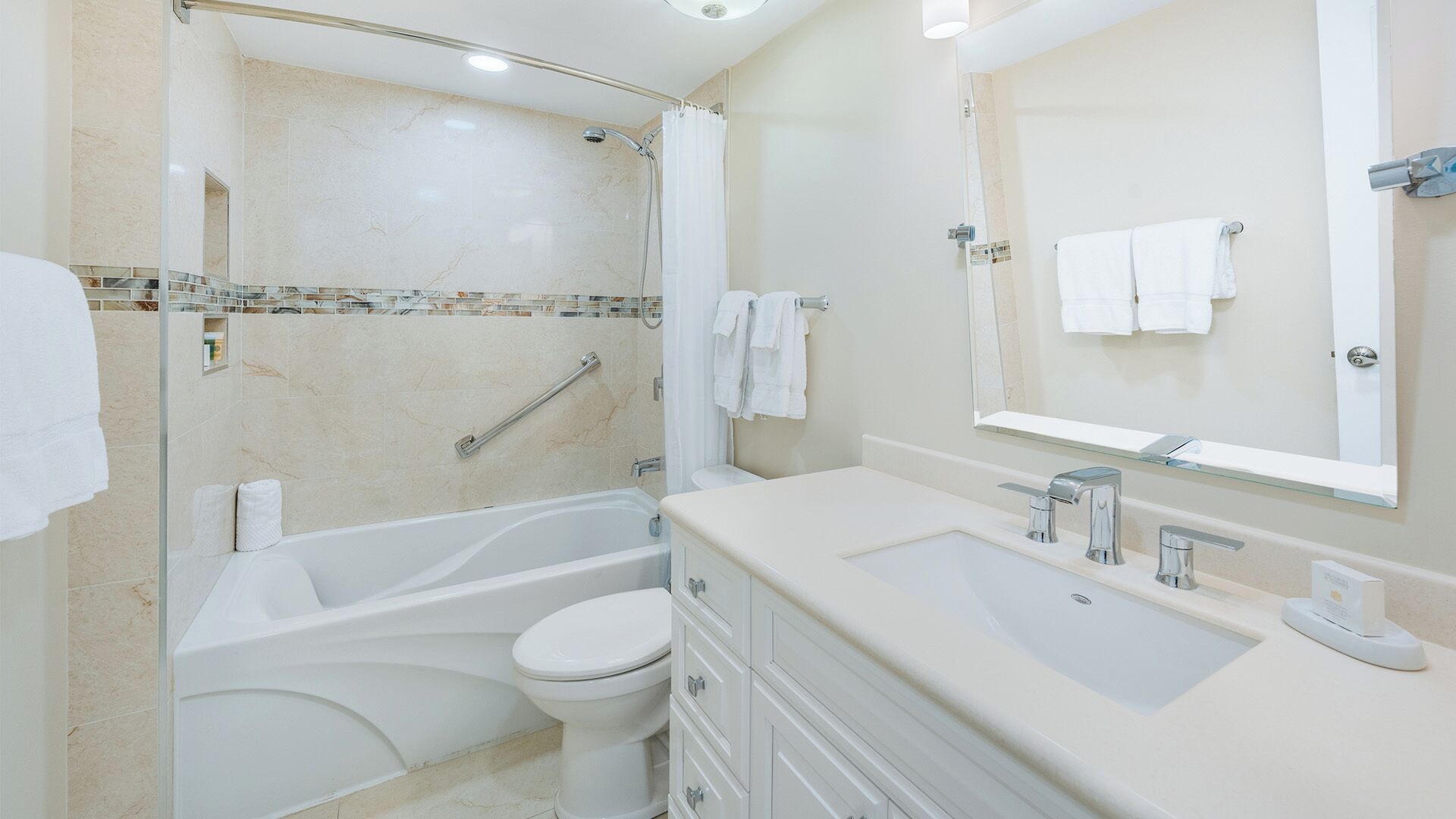 A modern bathroom with a bathtub, toilet, and vanity.