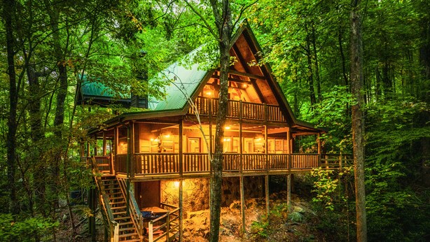 A wooden cabin with a balcony, surrounded by dense forest. - Up The Creek Cabin - Peaceful surroundings on a mountain stream (Sevierville)