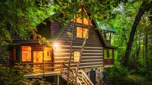 A log cabin with a wooden deck and a staircase leading to a second level. - Up The Creek Cabin - Peaceful surroundings on a mountain stream (Sevierville)