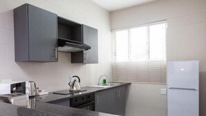 Una cocina moderna equipada con microondas, hervidor y tostadora de acero inoxidable.