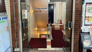 The entrance to a Vietnamese restaurant named THITHI, featuring a red carpeted staircase leading inside. - Poka Stay Kamata (Tokyo)