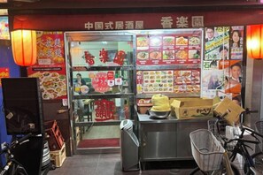 A food stall with a glass display case, menu boards, and a bicycle parked outside. - Poka Stay Kamata (Tokyo)