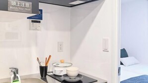A modern kitchen with a sink, a countertop, and a sign that reads 'Watch Your Head.' - Poka Stay Kamata (Tokyo)