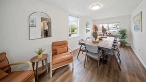 A dining area with a wooden table, chairs, and a small side table with a plant. - Group Ready 4BR near OSU w/ Fire Pit & Wet Bar (Columbus)
