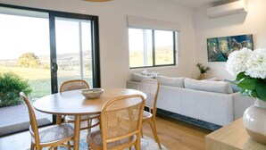 Un espace repas comprenant une table et des chaises, un canapé et une vue sur l’extérieur.