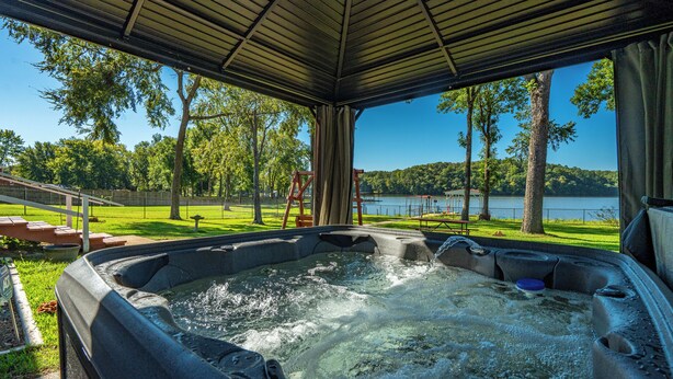 Un jacuzzi con vista a un lago y árboles.
