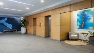 Een moderne lobby met een kaart aan de muur, een receptiebalie en een zithoek.