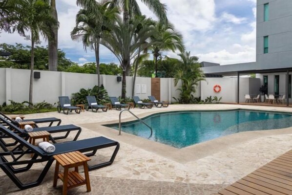 A poolside area with lounge chairs and a pool. - Holiday Inn Express SAN JOSE FORUM by IHG (Pozos)