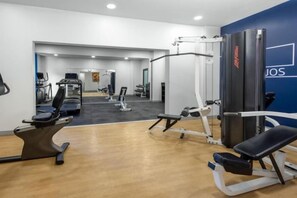 A gym with cardio machines, weight stations, and a mirror. - Holiday Inn Express SAN JOSE FORUM by IHG (Pozos)