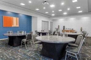 A conference room with round tables, chairs, and a blue accent wall. - Holiday Inn Express SAN JOSE FORUM by IHG (Pozos)