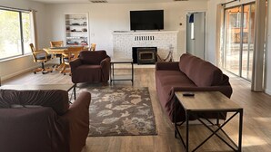 A modern living room with a fireplace, comfortable seating, and a television.