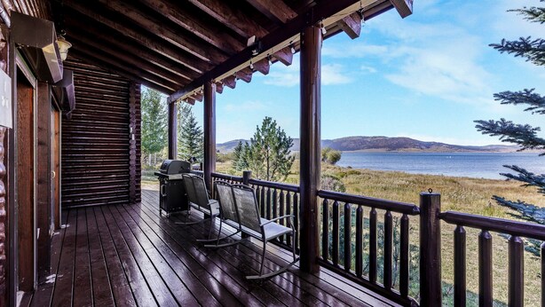 A wooden deck with a view of a lake and mountains. - HENRYS REEL RETREAT: Private Beach Dock on Henrys Lake Garage Yellowstone (Island Park)