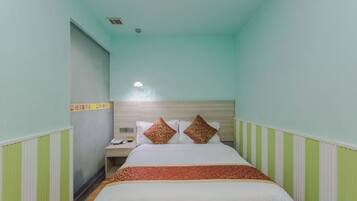 A narrow hotel room with a single bed, a nightstand, and a wall-mounted telephone.