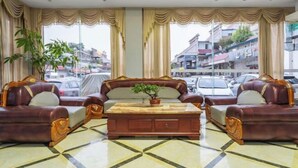 Una habitación con un conjunto de sofá, una mesa de centro y vistas a la calle.