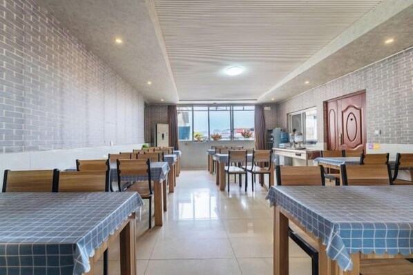 Un restaurante con paredes de ladrillo, mesas y sillas de madera, y vistas a través de amplios ventanales.